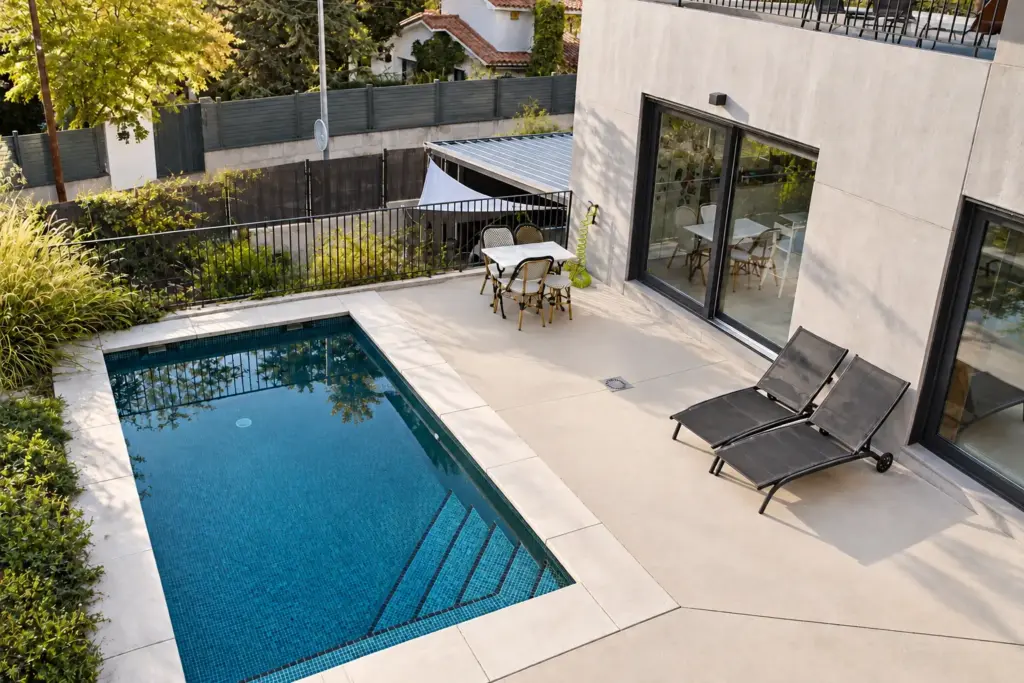 Patio moderno con piscina turquesa y terraza limpia